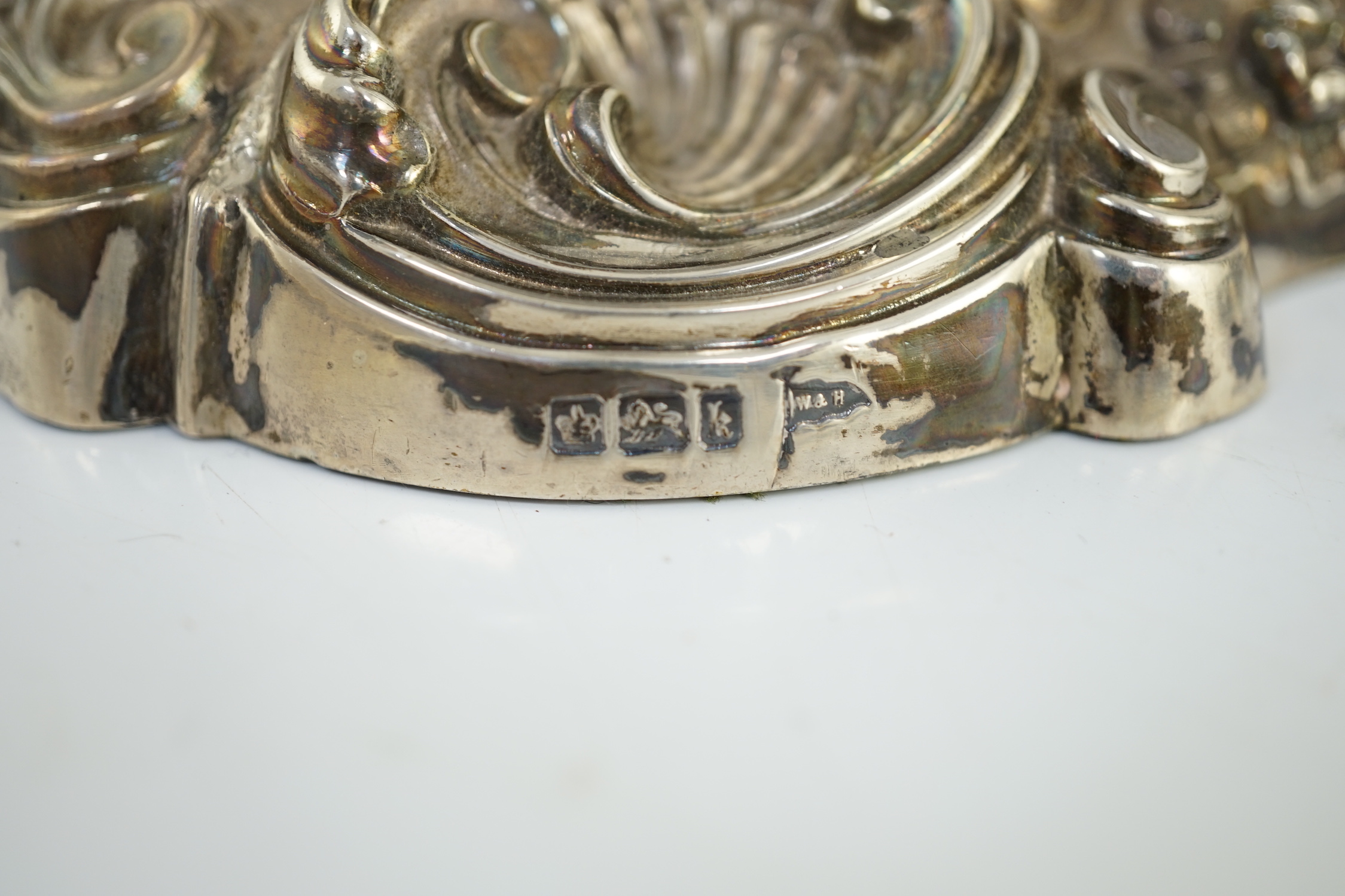 An ornate pair of Edwardian silver candlesticks, by Walker & Hall